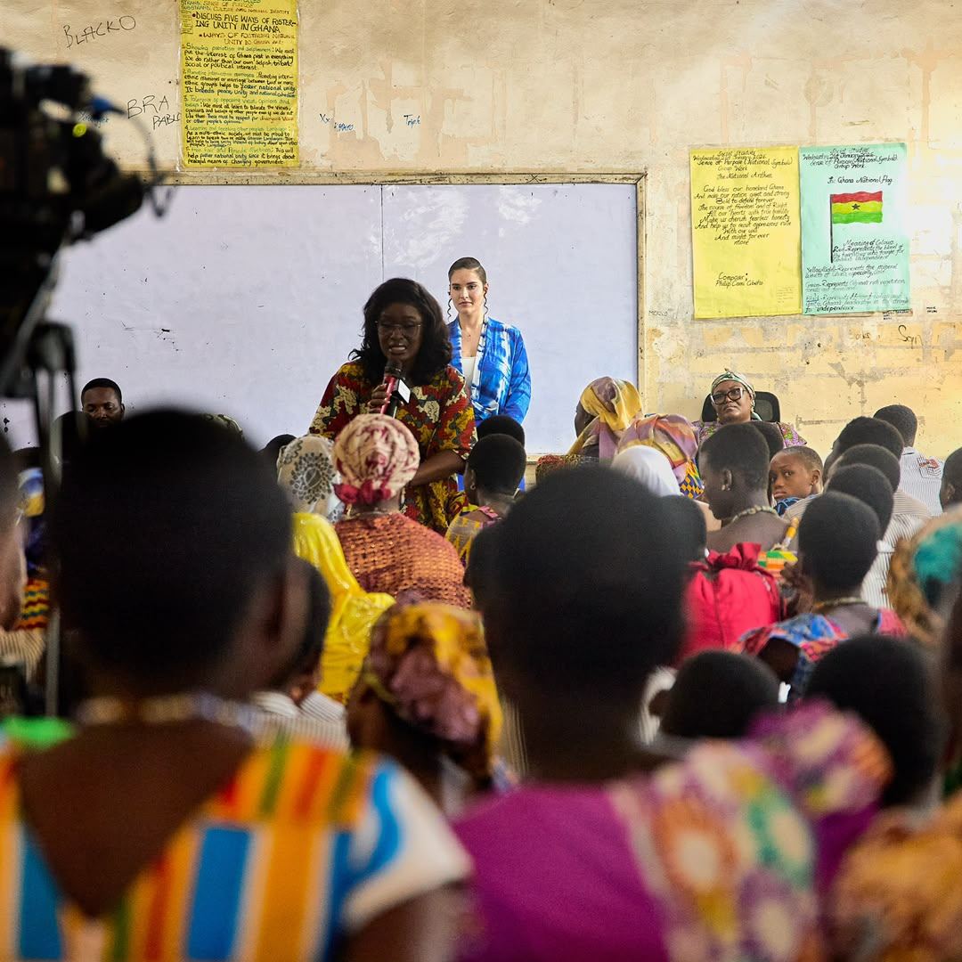 Shalimar Abbiusi leaning in to speak with women seated at a meeting
