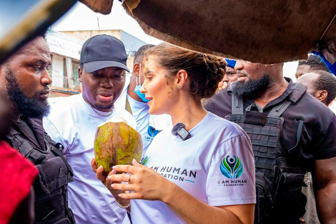 Shalimar Abbiusi holding a coconut among a crowd during a market visit