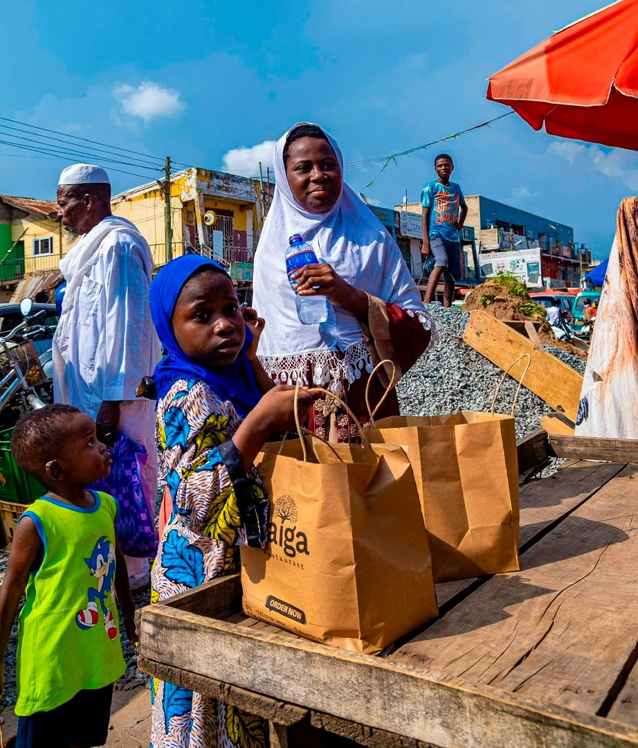 Volunteers handing out branded relief bags at a roadside stall