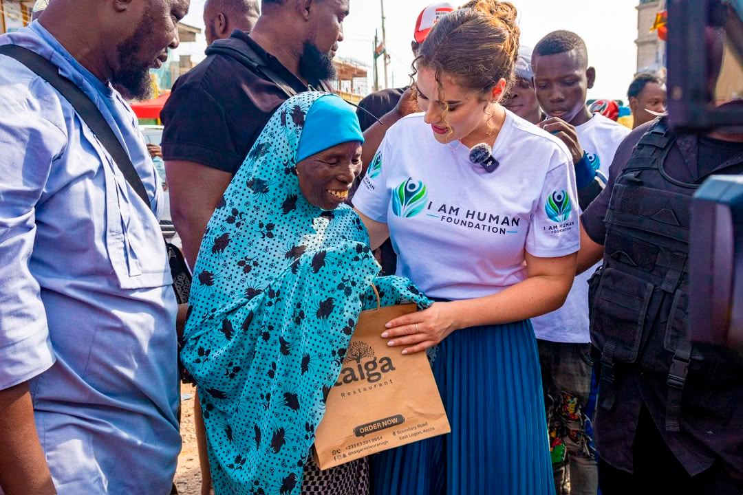 A woman smiling as she receives a bag of supplies