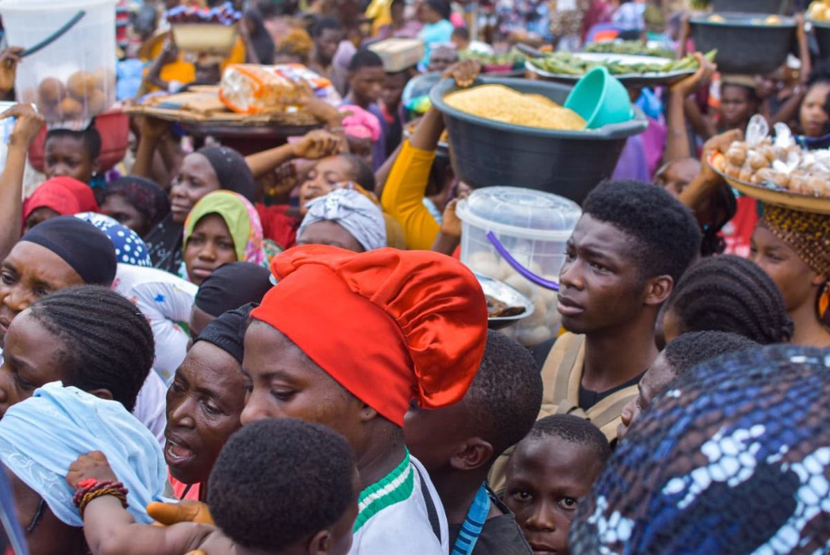 Traders and shoppers with baskets in a busy market