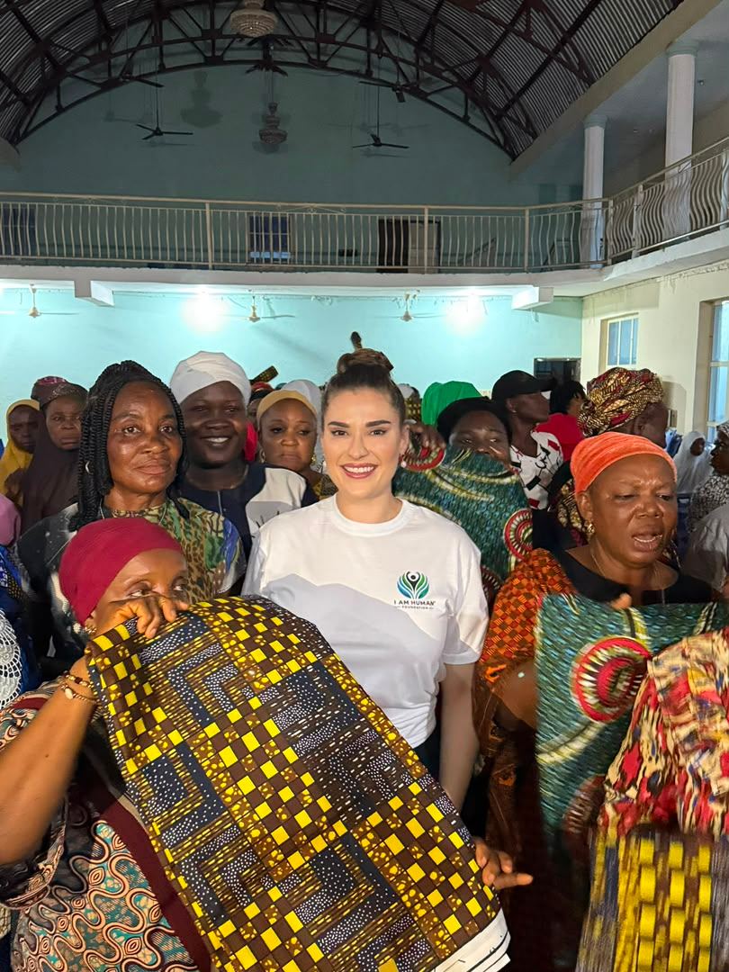 Shalimar Abbiusi and a community member holding lengths of fabric