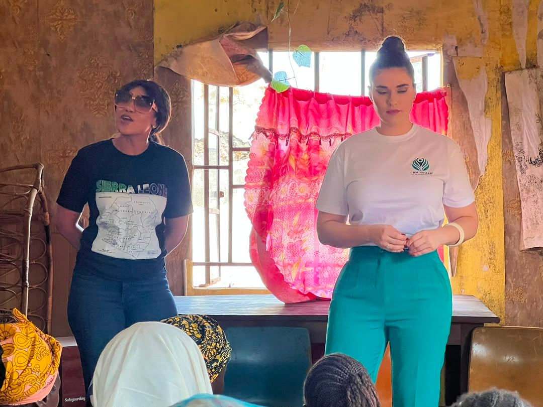 Shalimar Abbiusi addressing women seated in a village meeting hall