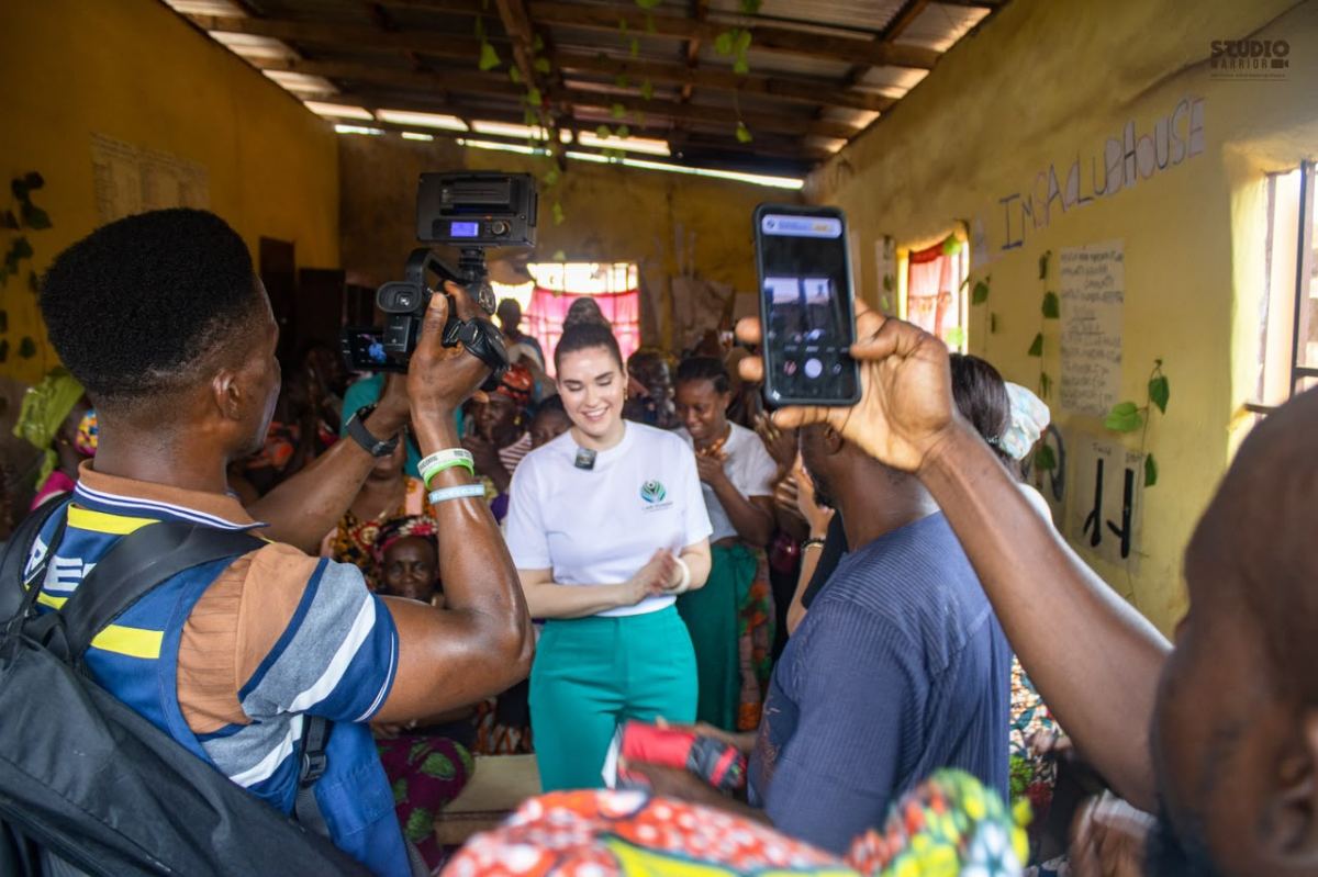 A community meeting being recorded inside a village building