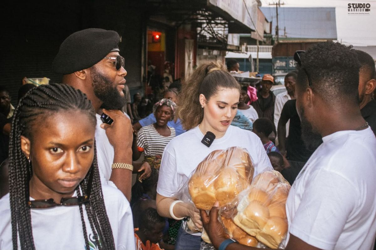 Volunteers carrying bags of bread through a crowd